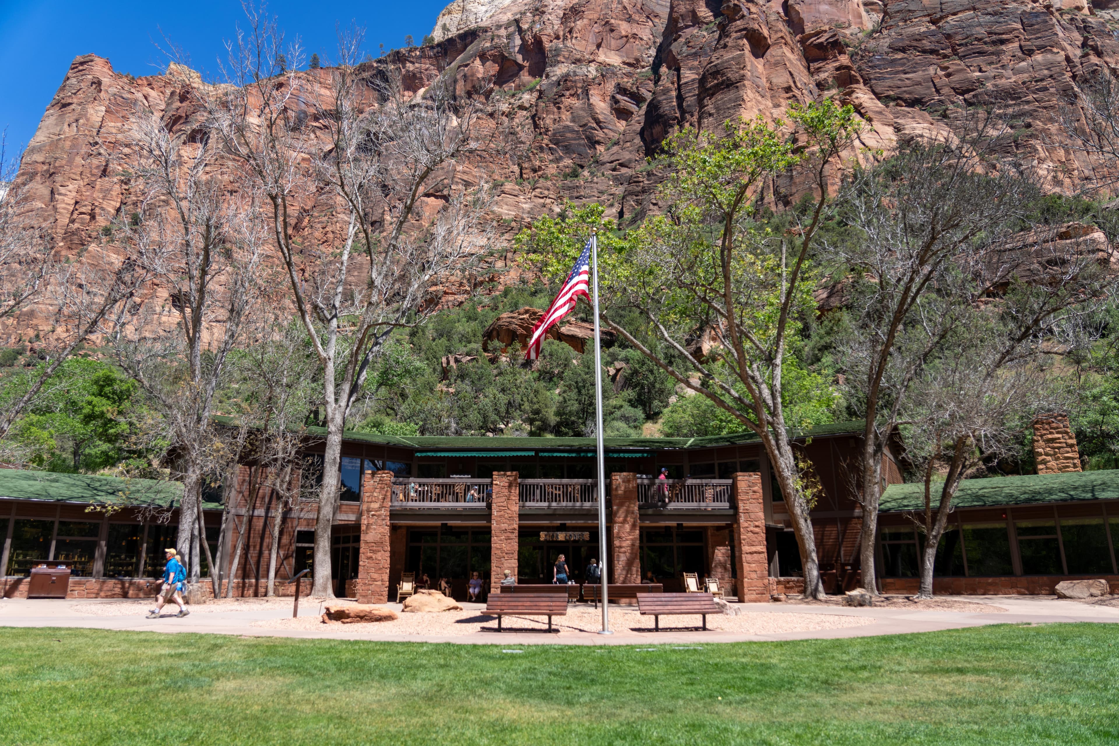 A dark brown building with a grassy green lawn in front.