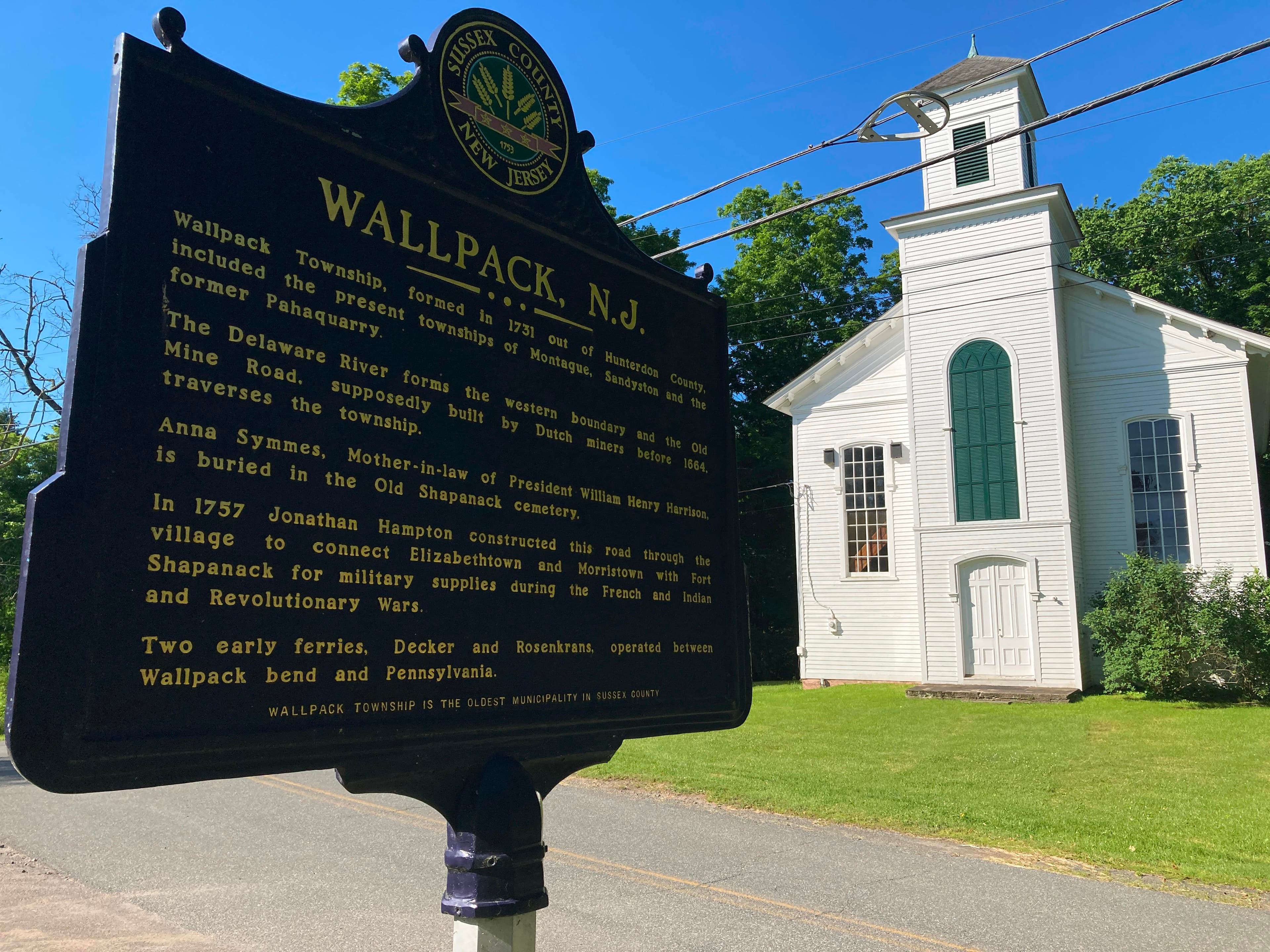 The historical marker for Walpack Center, NJ with the Walpack Church in the background.